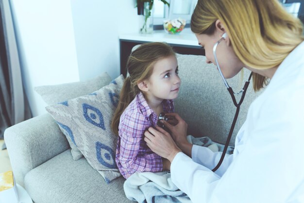 Un docteur est venu la voir et l&#39;a écoutée avec un stéthoscope