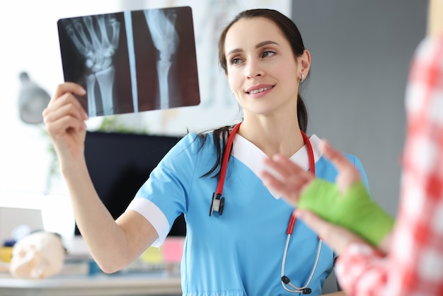 Le docteur examine la blessure à la main du patient sur une radiographie