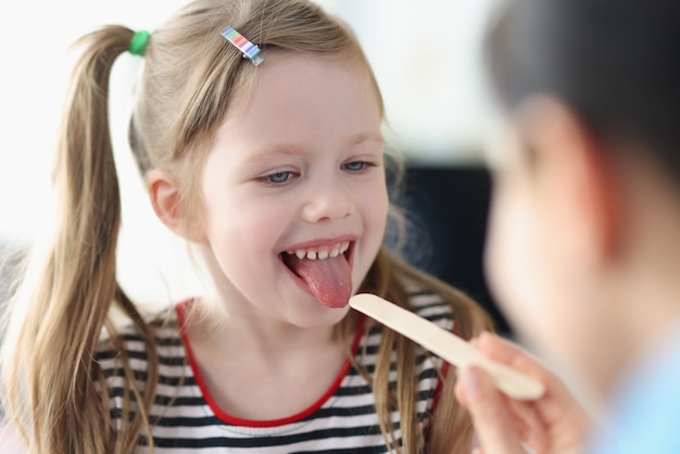 Le docteur examine la gorge du plan rapproché de petite fille