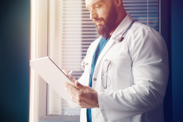 Photo le docteur examine l'information et écrit une prescription en ligne avec la technologie moderne