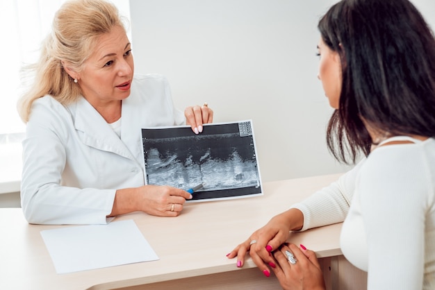 Le docteur examine la poitrine de la jeune femme. Consultation avec un gynécologue.