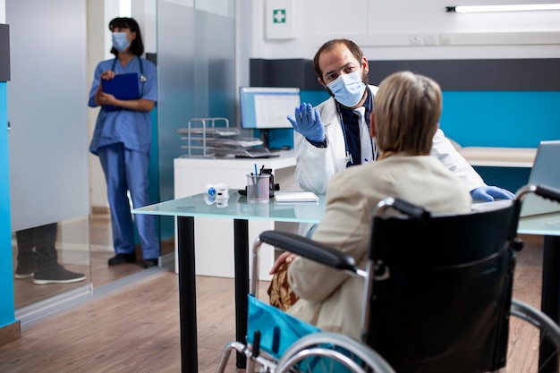 Le docteur explique le traitement à un vieux patient.