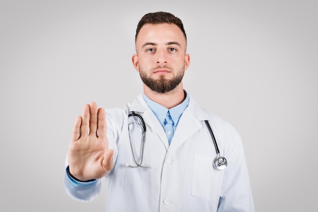 Le docteur fait un geste d'arrêt pour signaler la prudence.