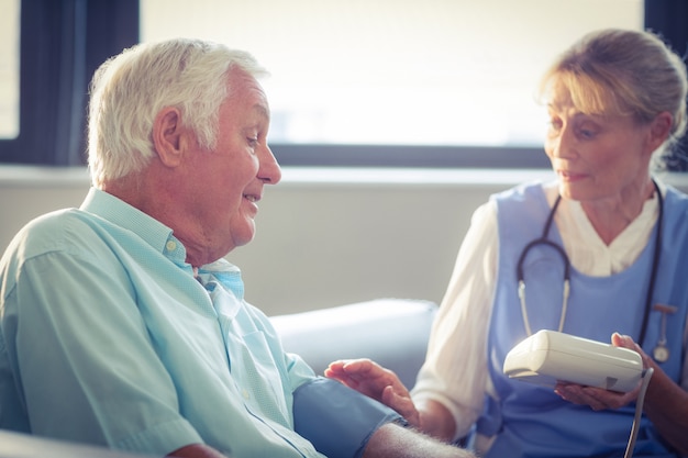 Docteur féminin, vérification, tension artérielle, de, homme aîné