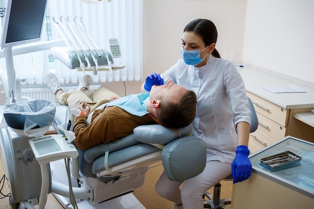 Docteur femme dentiste traite les dents du patient, des soins dentaires appropriés. Concept de soins dentaires et d'hygiène. Mise au point sélective.