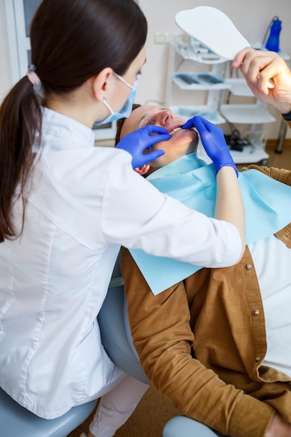 Docteur femme dentiste traite les dents du patient, des soins dentaires appropriés. Concept de soins dentaires et d'hygiène. Mise au point sélective.
