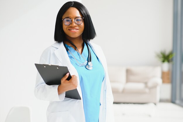 Docteur femme noire réussie souriant au bureau