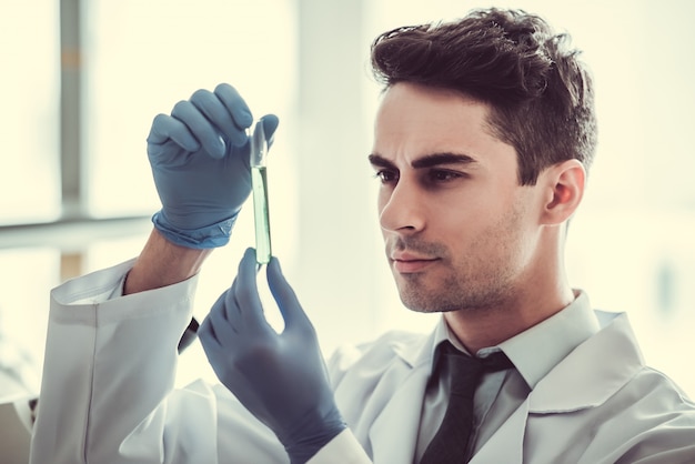 Docteur en gants travaille avec des éprouvettes au laboratoire.