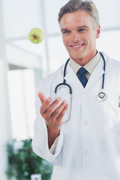 Docteur jetant une pomme verte