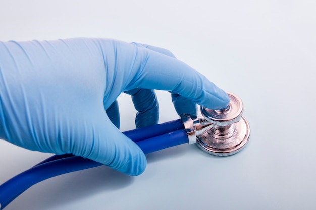 Docteur main dans des gants bleus avec stéthoscope