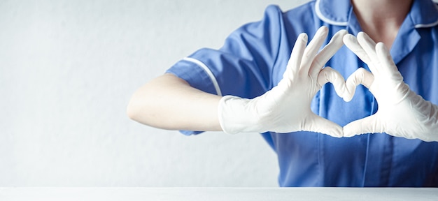 Docteur mains dans un gant en latex et montre le symbole du cœur. Docteur pour le cœur. J'adore nos professionnels de la santé.