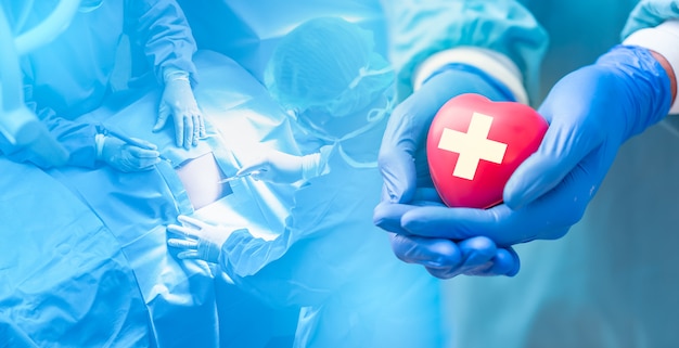 Docteur mains tenant un coeur rouge avec cardiogramme, concept de soins de santé.