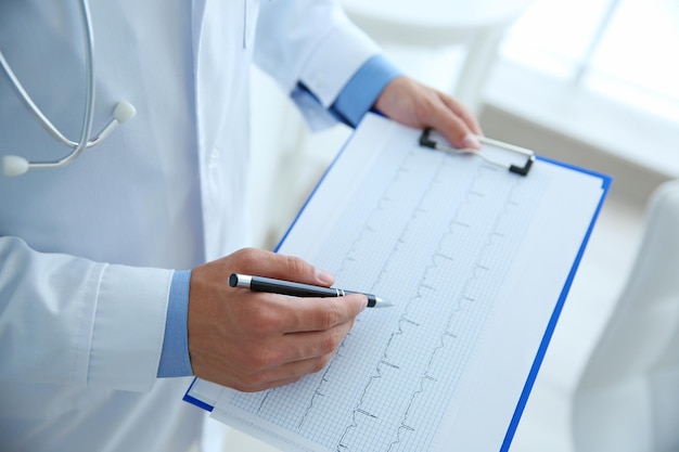 Docteur masculin au travail dans le bureau de la clinique