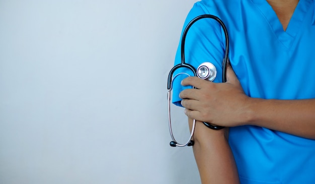 Docteur masculin tenant le stéthoscope avec le bras croisé