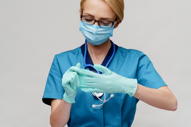 Docteur en médecine infirmière femme avec stéthoscope portant un masque de protection et des gants en caoutchouc ou en latex