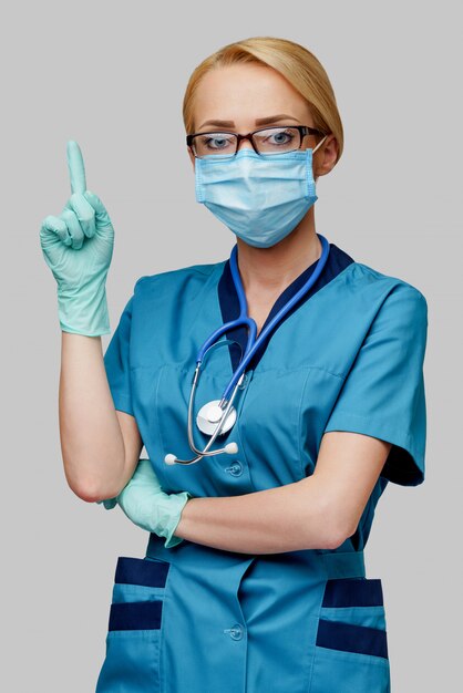 Docteur en médecine infirmière femme avec stéthoscope portant un masque de protection et des gants en caoutchouc ou en latex