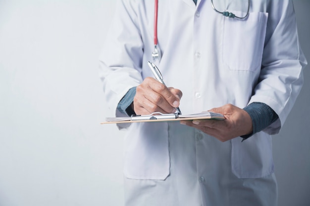 Docteur en médecine avec stéthoscope et tenant le formulaire de demande sur blanc.