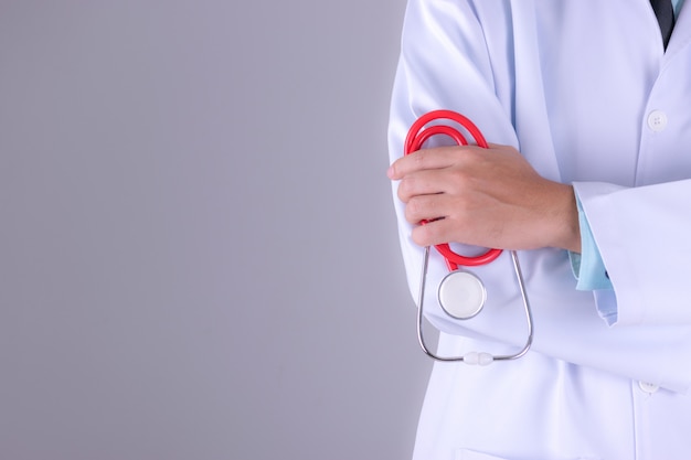 Docteur En Médecine En Uniforme De Robe Blanche Avec Stéthoscope à L'hôpital Sur Fond De Mur Blanc