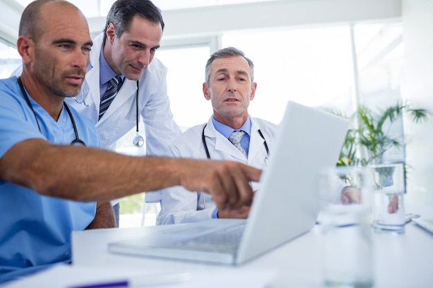 Docteur montrant pc ordinateur portable à ses collègues