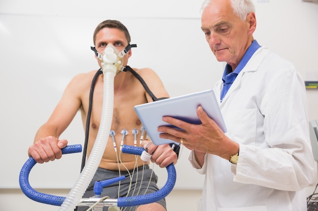 Docteur montrant tablet pc à l&#39;homme faisant des tests de condition physique