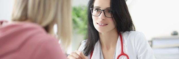 Le docteur montre à la patiente une radiographie des poumons sur le concept d'examen aux rayons x de la tablette