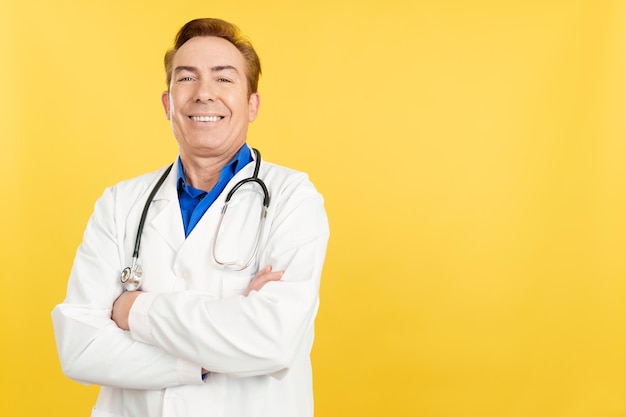 Docteur mûr regardant l'appareil-photo avec des bras croisés