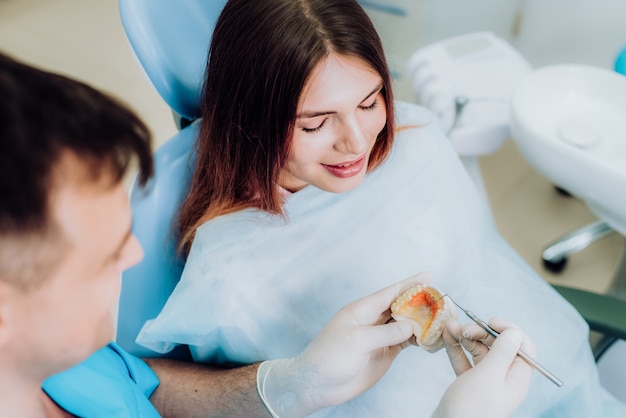 Docteur orthodontiste a montré comment la plaque fonctionne pour aplatir les dents sur les mâchoires