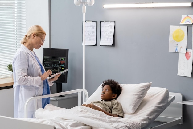 Docteur parlant au petit garçon à la salle d'hôpital