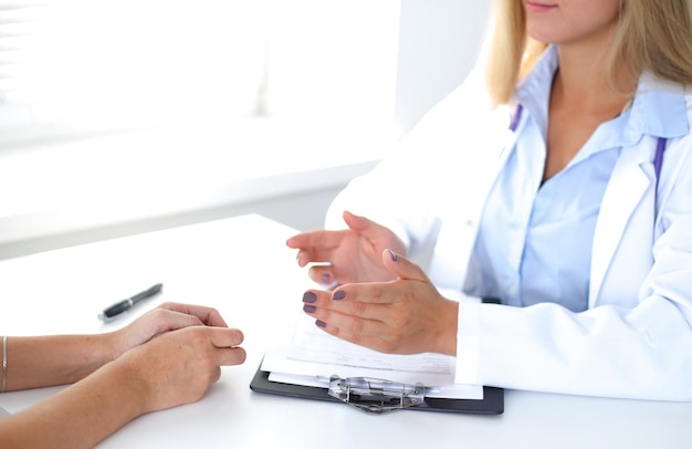 Le docteur et le patient discutent quelque chose, juste des mains à la table.