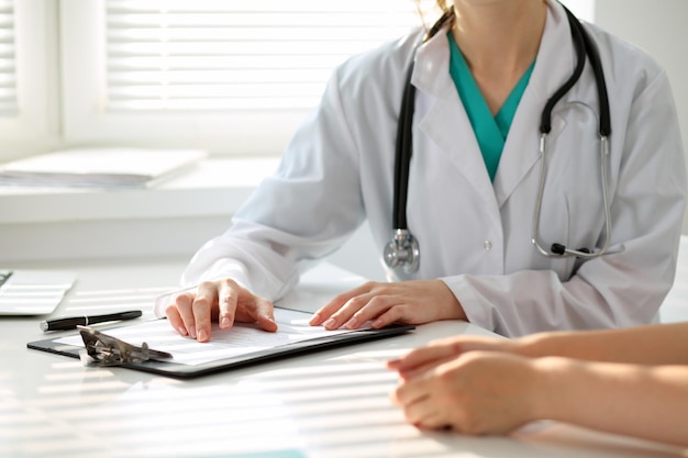 Le docteur et le patient discutent quelque chose, juste des mains à la table.