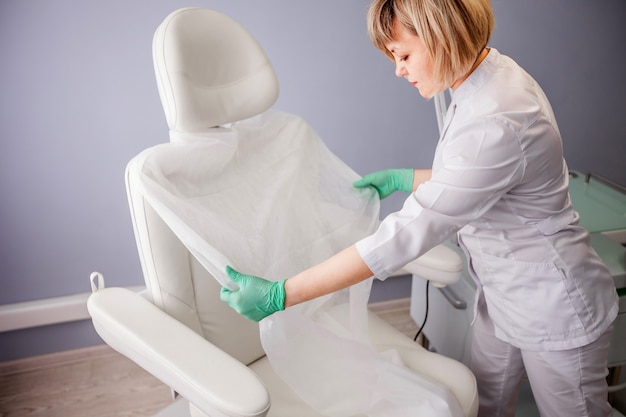 Docteur plaçant un chiffon jetable sur une chaise