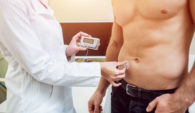 Photo docteur, à, a, pompe insuline, connecté, dans, patient, abdomen