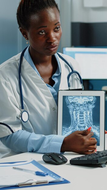 Photo docteur portant un masque montrant une tablette médicale