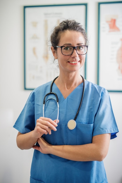 Docteur posant dans sa salle de consultation.