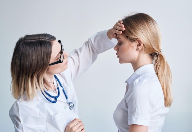 Docteur en robe médicale mesure la température d'une patiente fournissant des services médicaux Photo de haute qualité