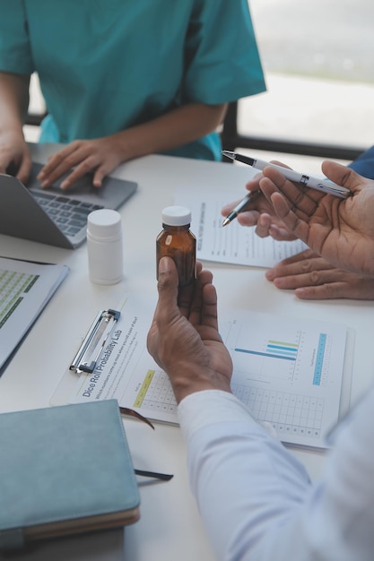 Docteur s'asseyant au bureau et écrivant une prescription pour son patient