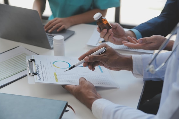 Docteur s'asseyant au bureau et écrivant une prescription pour son patient