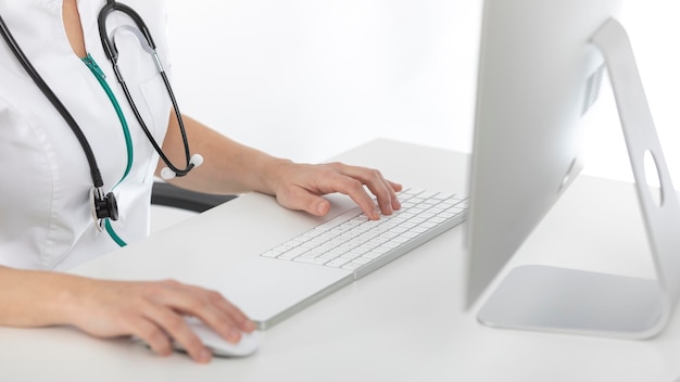 Photo docteur à son bureau regardant l'ordinateur