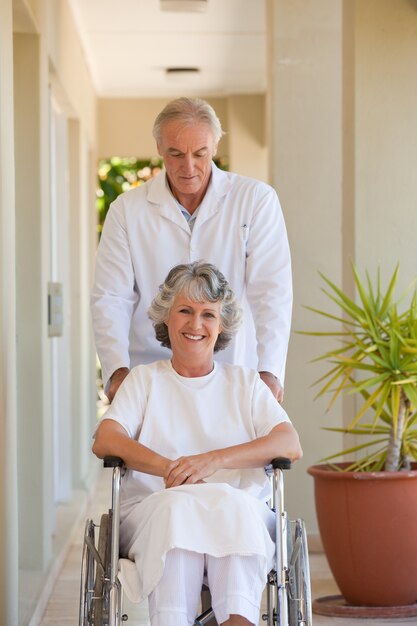 Docteur avec son patient dans son fauteuil roulant
