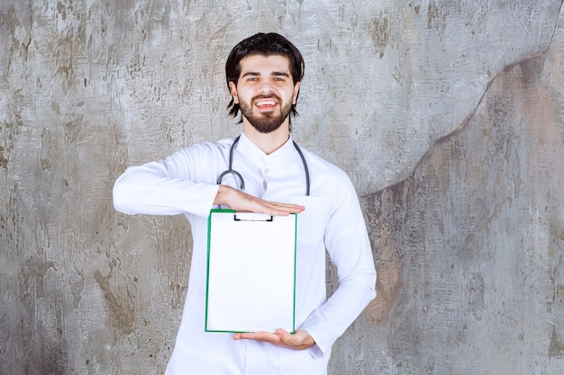 Docteur avec un stéthoscope présentant l'histoire d'un patient et se sentant positif