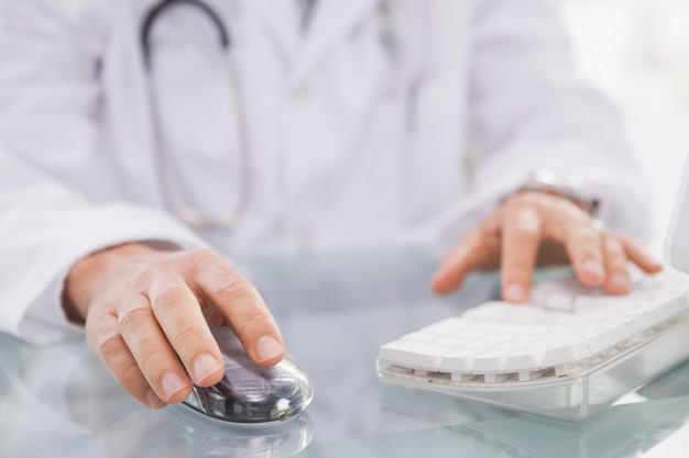 Docteur en tapant sur le clavier et en utilisant la souris