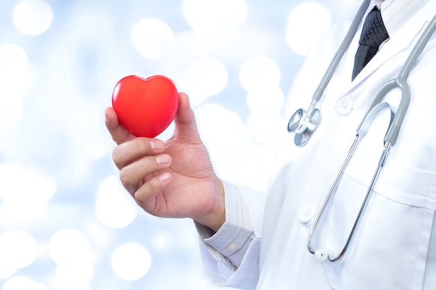 docteur tenant une boule de coeur rouge dans le fond de l&#39;hôpital.