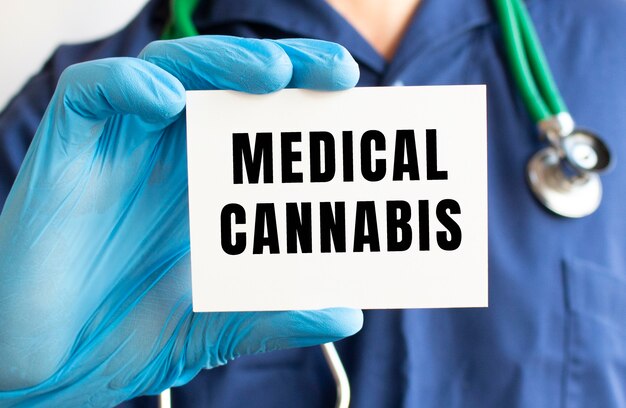 Docteur tenant une carte avec du texte CANNABIS MÉDICAL. Notion médicale.