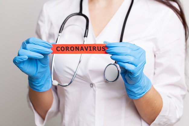 Docteur tenant une carte papier avec texte coronavirus