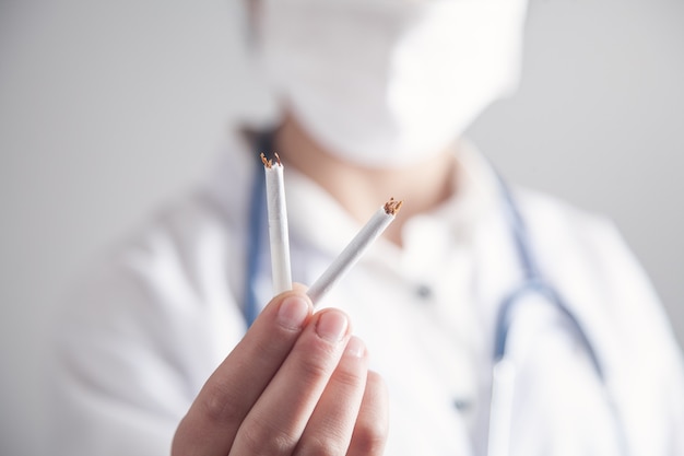 Docteur tenant une cigarette cassée. Arrêter de fumer