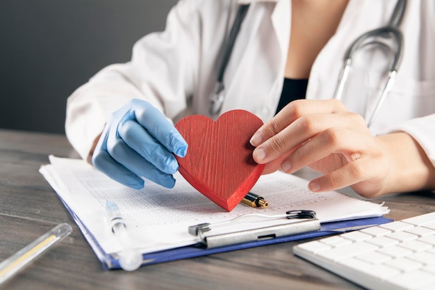 Docteur tenant un coeur rouge dans ses mains