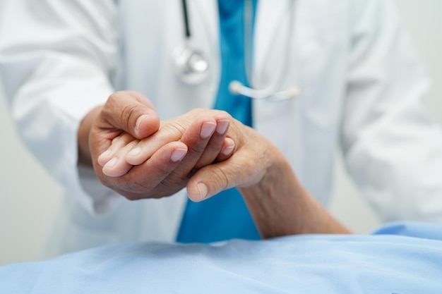 Docteur tenant la main d'une femme âgée asiatique patient aide et soins à l'hôpital