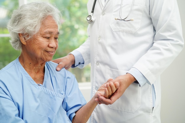 Docteur tenant la main d'une femme âgée asiatique patient aide et soins à l'hôpital