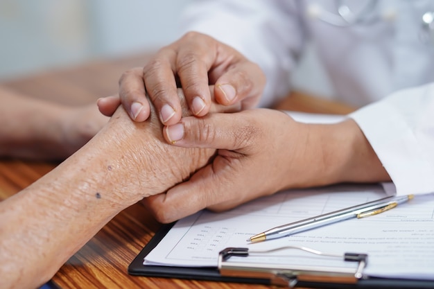 Docteur, tenant mains, à, asiatique, femme aînée, patient, à, love.