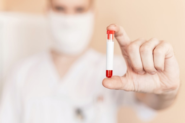 Le docteur tient dans ses mains un tube à essai vide en verre. Fermer.